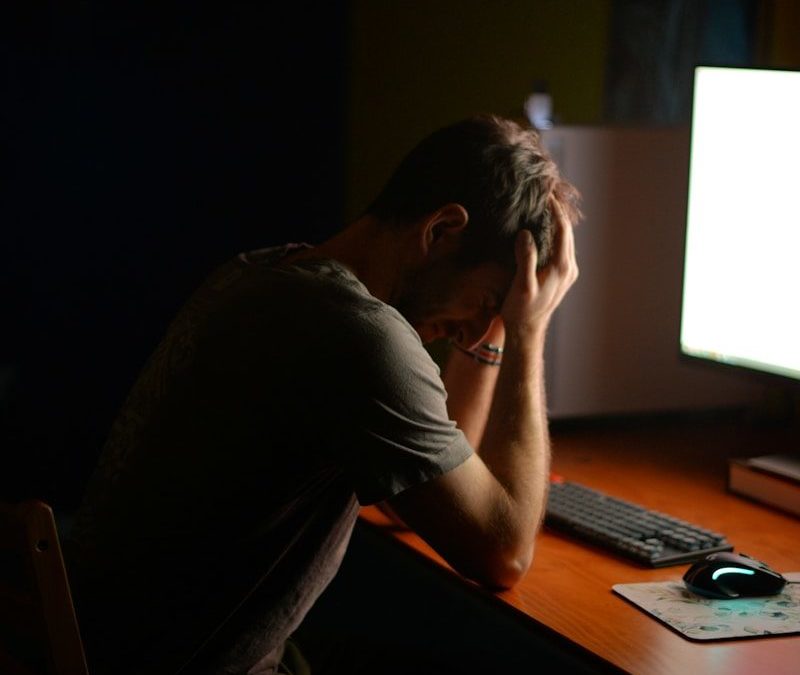 a man sitting at a desk in front of a computer